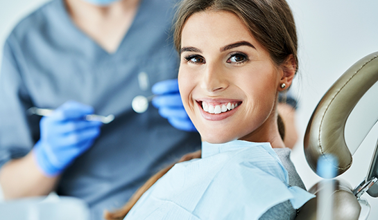 Woman sitting in dental chair smiling