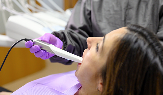 Female dental patient having teeth examined with intraoral camera