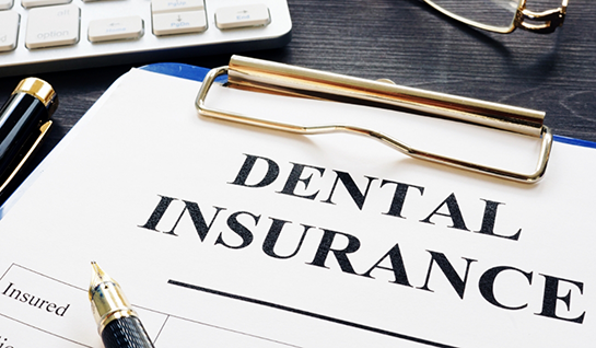 Dental insurance form on clipboard on busy desk
