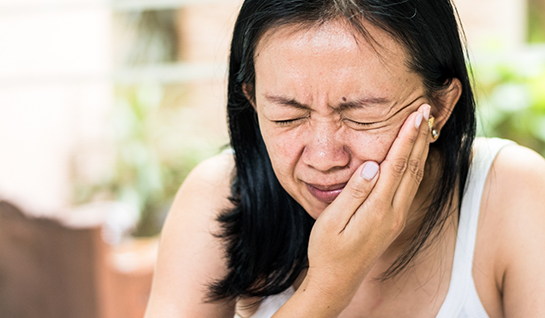 Woman rubbing her jaw in pain